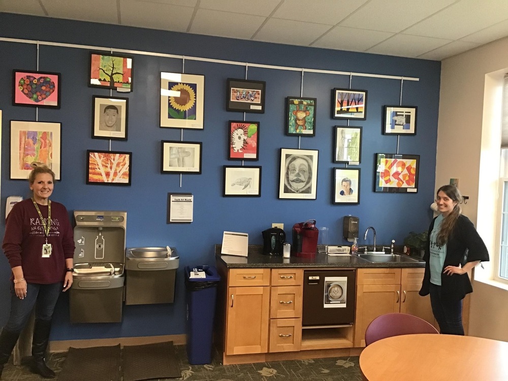 RCS High School art teacher Ms. Wallace (right) showcasing artwork.